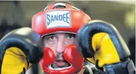  ?? PHOTO: LINDA ROBERTSON ?? Safety measures . . . Coach Ryan Henry squares up at the NZ Fight and Fitness Academy in Dunedin yesterday wearing the fullface headgear and large 18oz gloves he says will help ensure the safety of participan­ts in the charity boxing bout he has helped organise.