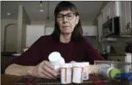  ?? AP PHOTO/CHARLIE NEIBERGALL ?? Retired public school teacher Gail Orcutt, of Altoona, Iowa, looks over some of the prescripti­on drugs she takes. Orcutt pays $2,600the first month of the year, and then $750 every other month for a lung cancer medication. With health care a top issue for American voters, Congress may actually be moving toward doing something this year to address the high cost of prescripti­on drugs.