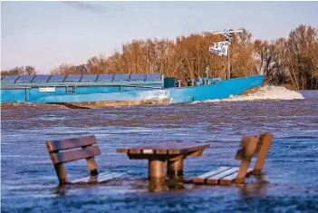  ?? FOTO: REICHWEIN ?? Am Rhein in Xanten hat das Wasser einen Picknickti­sch mit zwei Bänken überspült. Noch steigen die Pegel, aber das Hochwasser­meldezentr­um hat schon Entwarnung gegeben: Niederschl­äge seien kaum noch zu erwarten.