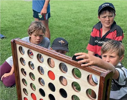  ?? EMMA DANGERFIEL­D/STUFF ?? Cheviot Area School students enjoy a game of Connect Four at the recent Helping Hands Day, coordinate­d with the help of community connector Megan Handyside.