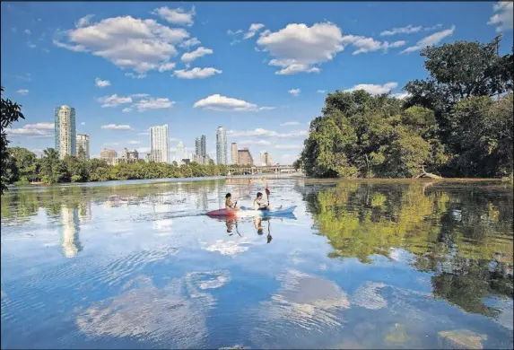  ?? BY AUSTIN CONVENTION & VISITORS BUREAU CONTRIBUTE­D ?? Kayakers take in the skyline from Lady Bird Lake, which is encircled by a hiking-and-biking trail that stretches more than 10 miles.