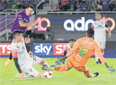  ?? JORGE OSUNA ?? > Giovanni Augusto, de Mazatlán FC, saca un zurdazo y tapan el balón Jesús Angulo y el portero Camilo Vargas.