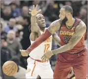  ?? TONY DEJAK - ASSOCIATED PRESS ?? The Cavaliers’ LeBron James, right, passes against the Hawks’ Taurean Prince in the first half of Tuesday’s game.