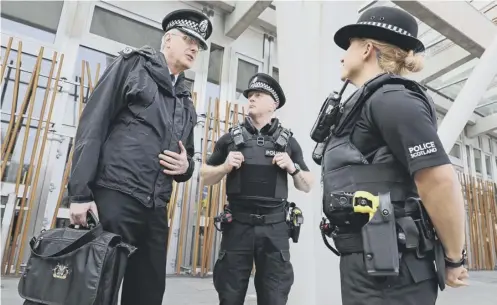  ?? PICTURE: PA ?? 0 Chief Constable Phil Gormley talks to officers with Tasers outside the Scottish Parliament