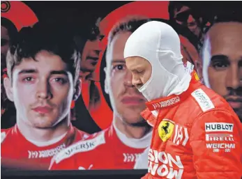  ?? FOTO: AFP ?? Sebastian Vettel auf dem Weg zur Ferrari-Box, im Hintergrun­d sein Konterfei und das seines Teamkolleg­en Charles Leclerc. Die Stallregie der Scuderia war in Schanghai großes Thema.