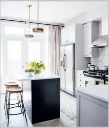  ??  ?? ABOVE & OPPOSITE Minor changes in the small kitchen garnered big results. The marble backsplash was a worthwhile splurge for the crisp visual interest it offers. Floating wooden shelves warm up the neutral, which originally had a boxy bank of ugly...