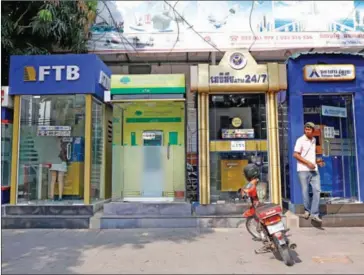  ?? PHA LINA ?? A man exits an ATM on Norodom Boulevard in central Phnom Penh last month. ATM infrastruc­ture and staff quality both scored poorly in a recent consumer survey of the banking industry.