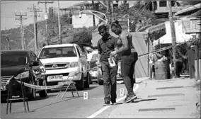  ??  ?? Crime Scene Investigat­ors search for spent rounds following the early morning shooting of three women along the Carenage Main Road on Saturday. (Photo Trinidad Guardian)