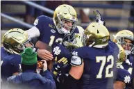  ?? Matt Cashore / Associated Press ?? Notre Dame quarterbac­k Ian Book ( 12) celebrates after running for a touchdown against Syracuse on Saturday.