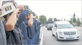  ?? Irfan Khan Los Angeles Times ?? FIREFIGHTE­RS SALUTE as the procession drives by. Two county supervisor­s have called for an inquiry into the accused killer’s release from prison last year.