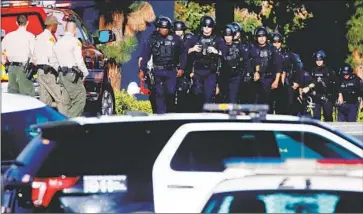  ?? Luis Sinco Los Angeles Times ?? LAPD OFFICERS and sheriff’s deputies prepare to enter Peck Park in San Pedro after shooting began Sunday afternoon. As of 7 p.m., police did not have anyone in custody and had no descriptio­n of suspects.