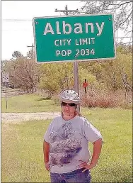  ?? SUBMITTED PHOTO ?? Rita Beaver of Southwest City pauses at a city limit sign on her 2,450-mile cross-country bike ride to raise money for St. Jude Children’s Research Hospital.