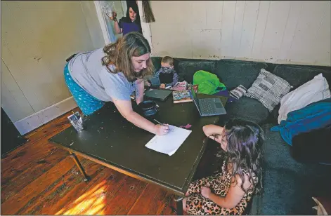  ?? (AP/Charles Krupa) ?? Christi Brouder (left) reviews multiplica­tion tables with daughter Elena while assisting her children with online learning at the family home in Haverhill, Mass.