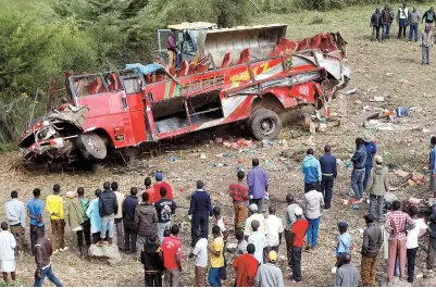  ??  ?? Residents survey the wreckage of a bus accident, near Fort Ternan, along the Londiani-Muhoroni road in Kericho county, Kenya, yesterday. At least 50 were killed in the crash. — Reuters