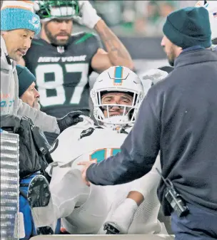  ?? N.Y. Post: Charles Wenzelberg ?? ANOTHER VICTIM: Dolphins linebacker Jaelan Phillips is carted off the field after suffering a noncontact Achilles injury during the fourth quarter.