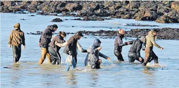  ??  ?? A beach landing near Dover docks as 409 migrants arrive in Britain yesterday