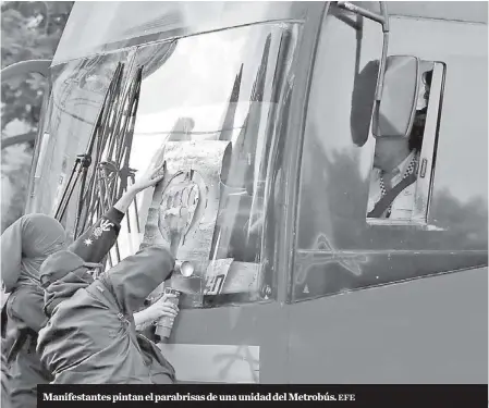  ?? EFE ?? Manifestan­tes pintan el parabrisas de una unidad del Metrobús.