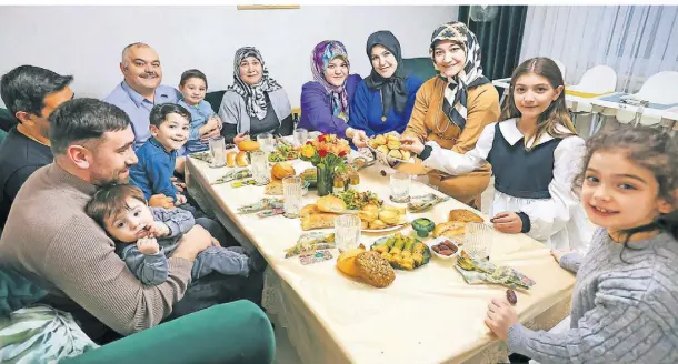  ?? FOTO: RUTH KLAPPROTH ?? Büsra Yilmas (5. v. re.) hat zum Fastenbrec­hen ihre Familie eingeladen. Sie reicht für die Vorspeise Gebackenes herum.