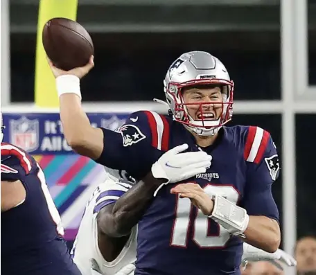  ?? NAncy LAnE / HErALd StAFF ?? NO QUIT: Patriots quarterbac­k Mac Jones is hits as he throws against the Cowboys on Sunday in Foxboro.