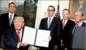  ?? JONATHAN ERNST / REUTERS ?? US President Donald Trump, flanked by Cabinet members and other officials, after signing a memo directing the US trade representa­tive to review of trade issues with China on Monday.
