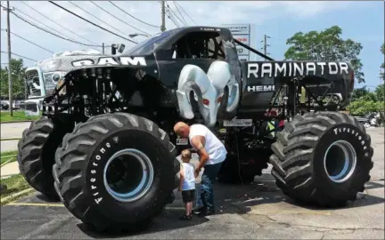  ?? BILL DEBUS — THE NEWS-HERALD ?? David Folk, of Geneva Township, and his grandson, 3-year-old Logan Folk of Thompson Township, check out the Raminator monster truck when it was on display June 17 at Adventure Chrysler Jeep Dodge Ram in Willoughby.