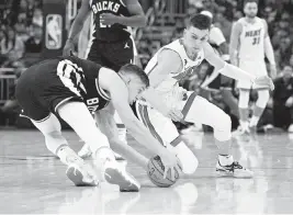  ?? MICHAEL MCLOONE USA Today Sports ?? Heat guard Tyler Herro, right, broke his right hand while diving for a loose ball lost by the Bucks’ Grayson Allen on April 16 in Milwaukee in Game 1 of the first round.