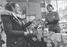  ?? DAN JANISSE ?? Cori Dufresne, left, makes a food donation at a station staffed by fellow student Himaja Yedidi this week at the University of Windsor. The school was one of the local agencies taking part in Giving Tuesday.