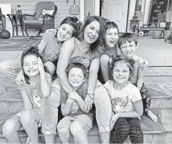  ?? ALYSSA SPERAZZA/ HOWARD CENTER FOR INVESTIGAT­IVE JOURNALISM ?? Ashley Fitzgibbon and her children sit outside their Oklahoma City rental home. Fitzgibbon lost her income when the state shut down. From left the Fitzgibbon family members are Adaley Joy, 9; Jayden Grace, 12; Rorke, 5; Ashley, 35; Judah, 10; M’kenna Lou Ann, 6, and Griffin, 8.