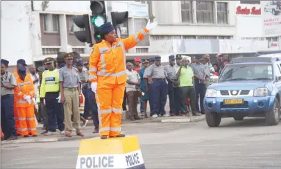  ?? Picture by Munyaradzi Chamalimba ?? A police officer controls traffic at the intersecti­on of Kenneth Kaunda Avenue and Julius Nyerere Way while donning a new uniform for traffic officers that was launched in Harare yesterday. —