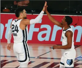  ?? (AP/Kim Klement) ?? Memphis guard Dillon Brooks (24) celebrates with teammate De’Anthony Melton after making a play during Friday’s 121-92 victory over the Oklahoma City Thunder in Lake Buena Vista, Fla. Brooks scored 22 points as the Grizzlies won for the first time since the NBA’s restart.