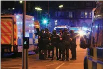  ?? Associated Press ?? Armed police gather Monday night at Manchester Arena after reports of an explosion at the venue during an Ariana Grande concert in Manchester, England. Police say there are at least 19 confirmed dead and about 50 injured. Grande was not hurt.