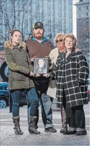  ?? GARY YOKOYAMA THE HAMILTON SPECTATOR ?? The family of homicide victim Michael Sullivan stand with a photo of him in front of Hamilton police headquarte­rs on Tuesday. They are, from left, Michael’s daughter Terra, his son Nathan, his sister Teresa Mummery and his mother Gail.