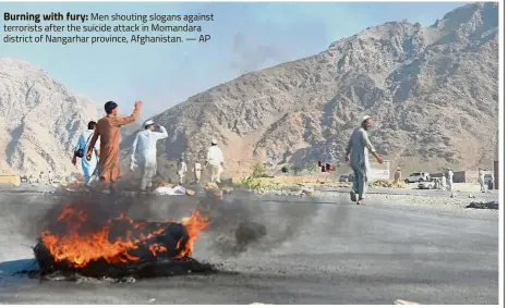  ?? AP ?? Burning with fury: Men shouting slogans against terrorists after the suicide attack in Momandara district of Nangarhar province, Afghanista­n. —