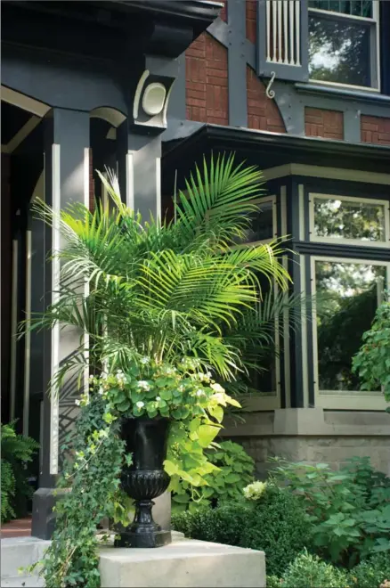  ?? PHOTOGRAPH­Y BY KATHY RENWALD, SPECIAL TO THE HAMILTON SPECTATOR ?? The colour scheme is simple green and white, but the impact is big. Urns on the front porch are a bold scale to complement the heritage home of Tom Couchman and David Wood on St. Clair Avenue.