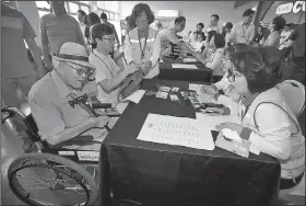  ?? AP/Yonhap News Service ?? South Koreans register Sunday at a hotel in Sokcho to participat­e in family reunions with their North Korean relatives this week at North Korea’s Diamond Mountain resort.