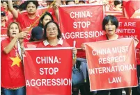  ?? (Romeo Ranoco/Reuters) ?? FILIPINO AND VIETNAMESE activists display placards yesterday during a rally over the South China Sea disputes in front of the Chinese Consulate in Makati, Philippine­s.