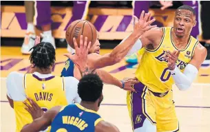  ?? FREDERIC J. BROWN AFP VIA GETTY IMAGES ?? Russell Westbrook, right, Anthony Davis and the Lakers went winless in the pre-season before losing their season opener to Andrew Wiggins and the Warriors.