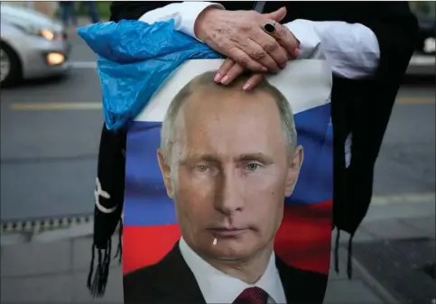  ?? ?? En kvinde holder et billede af den russiske praesident, Vladimir Putin, under en pro-russisk demonstrat­ion i den serbiske hovedstad Beograd. Foto: Darko Vojinovic/AP/Ritzau Scanpix