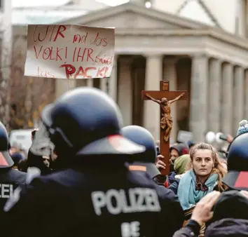  ?? Foto: Kay Nietfeld, dpa ?? Eine junge Frau stellt sich am vergangene­n Mittwoch bei Protesten gegen das neue Infektions­schutzgese­tz vor dem Brandenbur‰ ger Tor in Berlin Polizisten entgegen – mit einem Kruzifix.