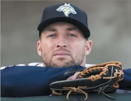  ?? PHOTOS BY SEAN RAYFORD — THE ASSOCIATED PRESS FILE ?? In this April 6 photo, Columbia Fireflies outfielder Tim Tebow looks out from the dugout before the team's minor league baseball game against the Augusta GreenJacke­ts in Columbia, S.C. Tebow has been promoted to the New York Mets' high Class A...