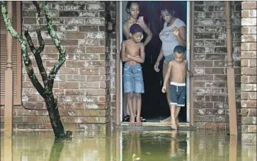  ?? Godofredo A. Vásquez Houston Chronicle ?? A FAMILY at home in Houston. Parts of the city had seen up to 14 inches of rain by Tuesday afternoon.