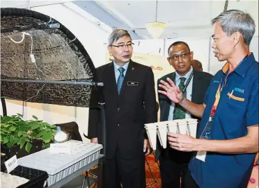  ??  ?? Looking to the future: Mah (left) being briefed on an exhibit by Humibo general-manager Lee Boon Kok (right) at the 13th National ISP Seminar while ISP chairman Datuk Daud Amatzin looks on.
