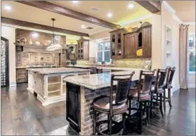  ??  ?? HARDWOOD FLOORS and beamed ceilings are among the features of the gated 2002 house that is listed at $7,999,950.