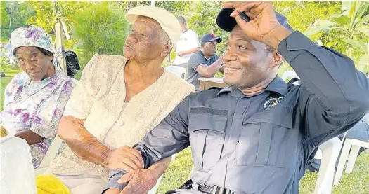  ?? CARL GILCHRIST ?? Centenaria­n Emilyn Rose with her favourite cop, Constable Charlton Bailey, at her 100th birthday party.