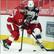  ?? PAUL SANCYA — THE ASSOCIATED PRESS ?? Detroit Red Wings’ Filip Hronek. left, and Columbus Blue Jackets’ Alexandre Texier battle for the puck during Monday’s game in Detroit. The Red Wings lost, 3-2.