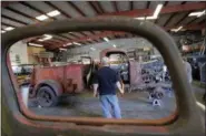  ?? GERALD HERBERT — THE ASSOCIATED PRESS ?? Joey Cullligan, restoratio­n specialist for the National WWII Museum, looks over a 1940’s era fire truck Wednesday in their warehouse in New Orleans.