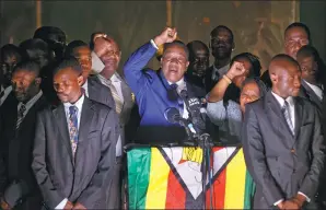  ?? BEN CURTIS / ASSOCIATED PRESS ?? Emmerson Mnangagwa, Zimbabwe’s incoming president (center), greets supporters gathered outside the ZANU-PF party headquarte­rs in Harare, Zimbabwe, on Wednesday.