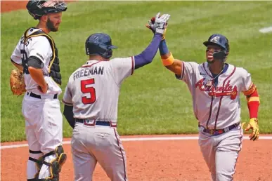  ?? AP PHOTO/GENE J. PUSKAR ?? The Atlanta Braves’ Ronald Acuna Jr., right, celebrates with Freddie Freeman (5) as Pittsburgh Pirates catcher Jacob Stallings, left, looks on, after hitting a solo home run off starter Wil Crowe during the third inning Wednesday.