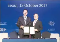  ?? Courtesy of KAIST ?? KAIST President Shin Sung-chul, right, poses with Murat Sonmez, a managing director who heads the World Economic Forum’s Center for the Fourth Industrial Revolution, after signing an MOU in Seoul in October 2017.