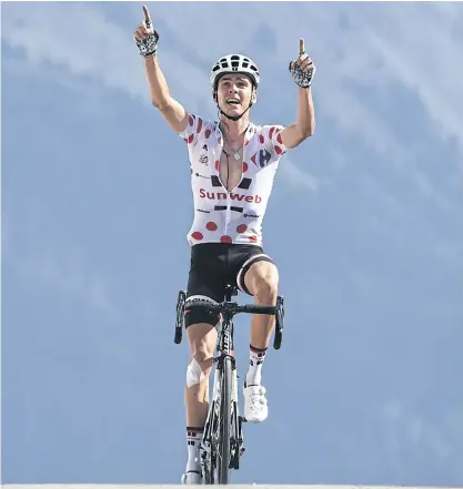  ??  ?? Warren Barguil, wearing the best climber’s polka dot jersey, celebrates as he crosses the finish line of the 18th stage.